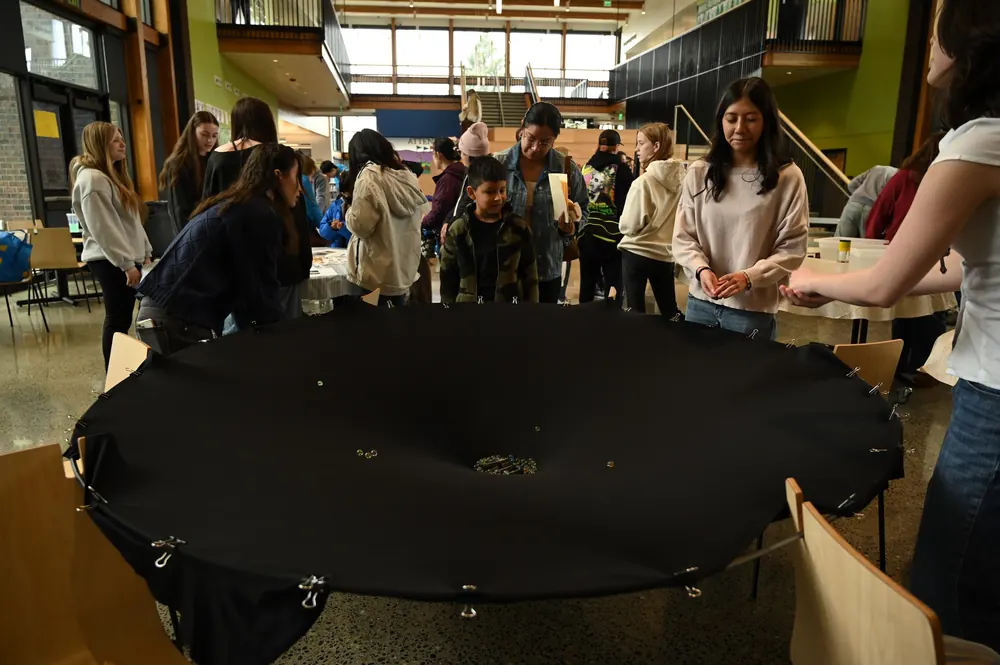 Students and families gathered around a large group activity