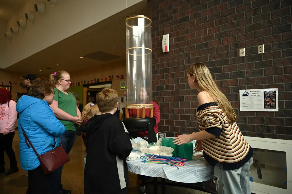 Families gathered around a science demonstration table